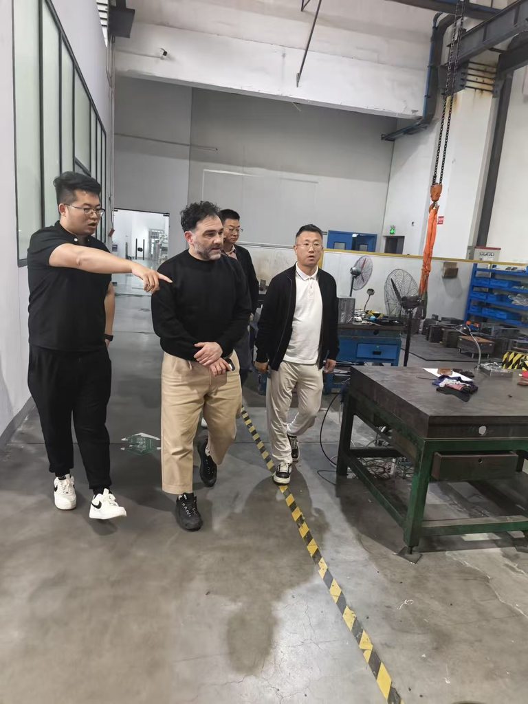 Jinxi staff guiding a visitor through a production workshop.