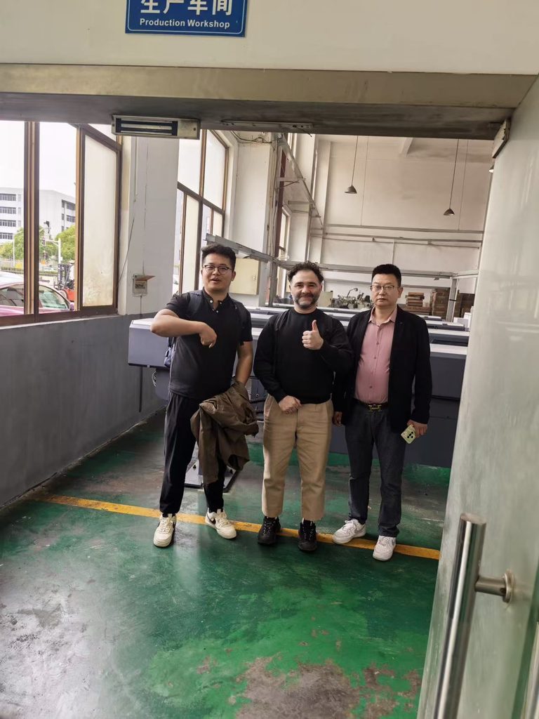 Jinxi staff and a visitor standing together in the production workshop.